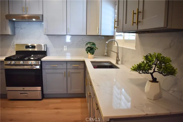 a kitchen with stainless steel appliances granite countertop a sink a stove and a microwave