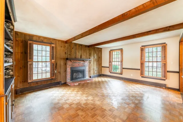a view of an empty room with a fireplace and a window