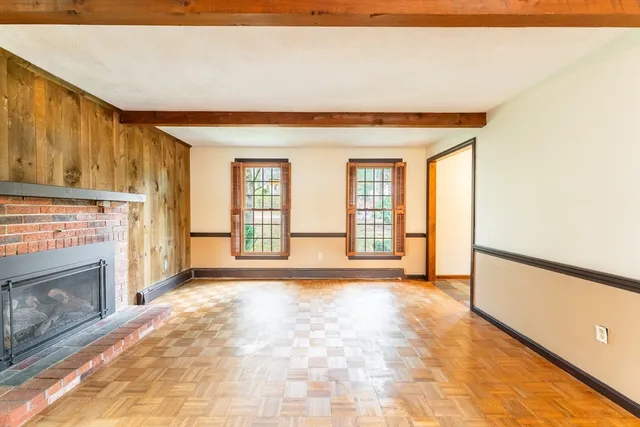 a view of an empty room with a fireplace and a window