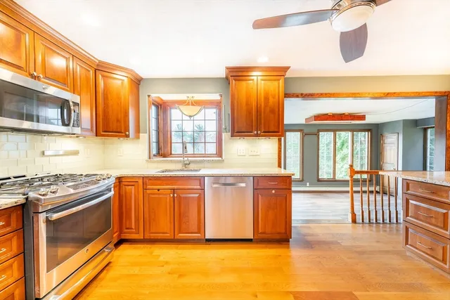 a kitchen with stainless steel appliances granite countertop a stove a sink and a microwave