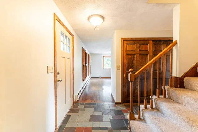 a view of a hallway with wooden floor and staircase