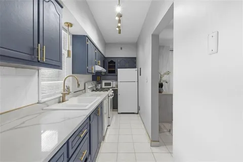 a kitchen with a sink a refrigerator and cabinets
