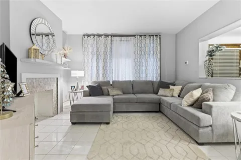 a living room with furniture a fireplace and a flat screen tv