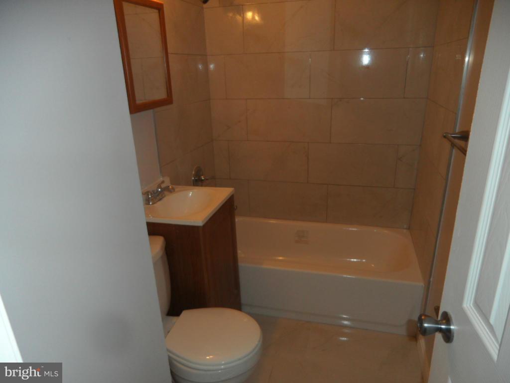 7855 Burnside Road Landover, MD 20785 - Photo 3 of 17 a bathroom with a sink a toilet and shower
