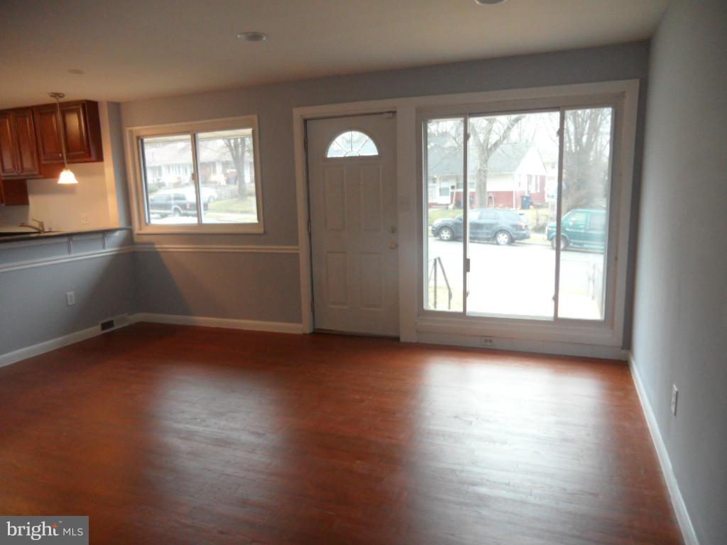 7855 Burnside Road Landover, MD 20785 - Photo 5 of 17 a view of an empty room with wooden floor and a window