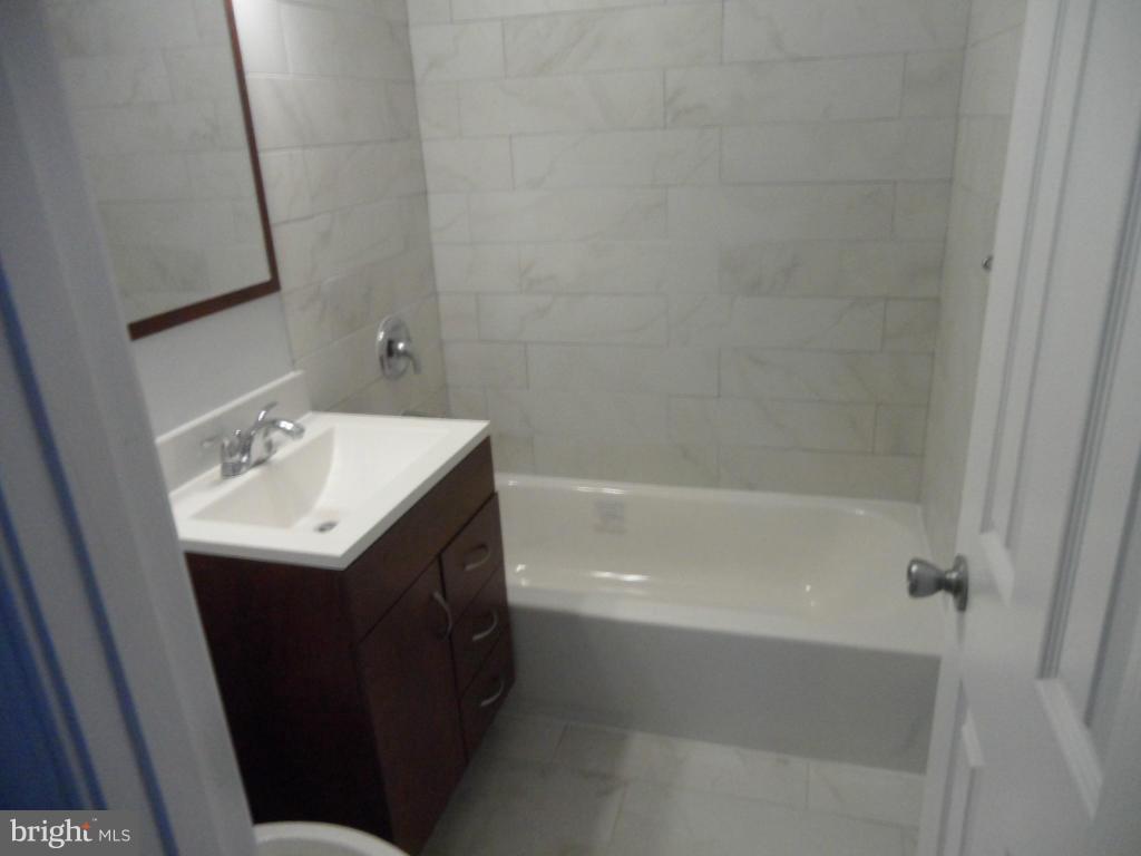 7855 Burnside Road Landover, MD 20785 - Photo 6 of 17 a bathroom with a sink a mirror and a bathtub