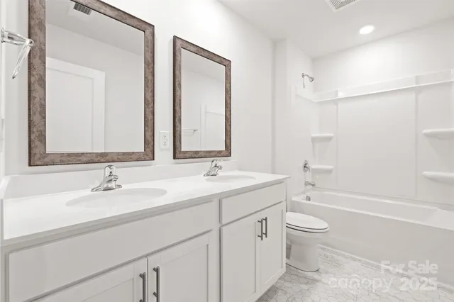 a bathroom with a sink double vanity granite toilet tub and shower