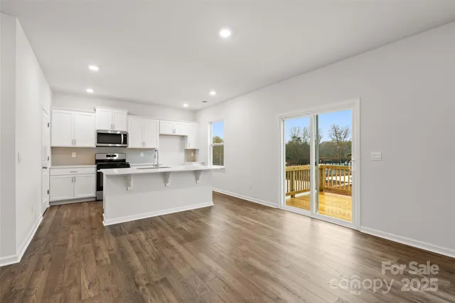 a kitchen with stainless steel appliances granite countertop a stove top oven a sink and a refrigerator