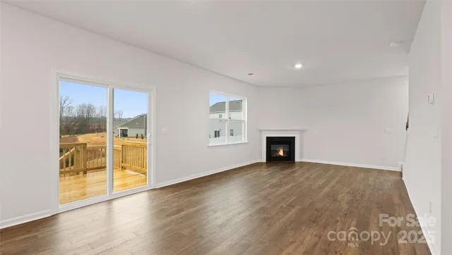 an empty room with wooden floor and fireplace