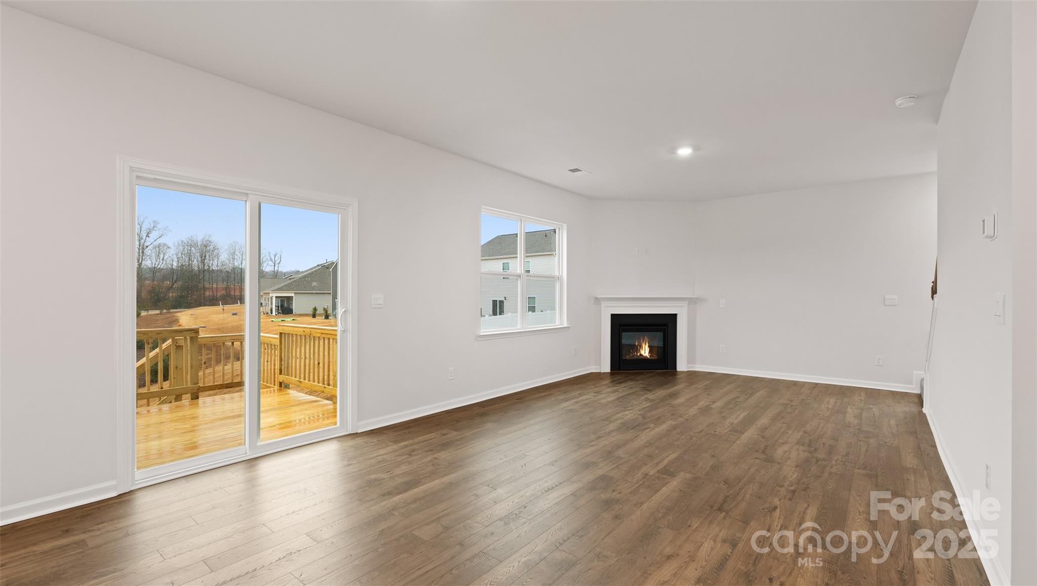 52 Shorthorn Road Fletcher, NC 28732 - Photo 9 of 28 an empty room with wooden floor and fireplace