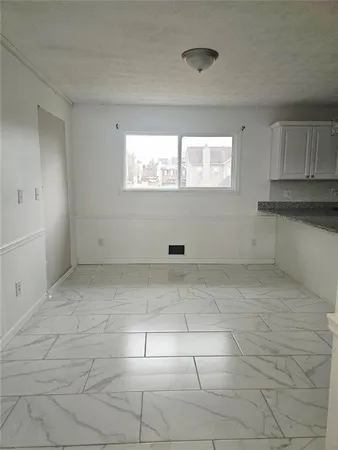 a view of kitchen with white cabinet and a window