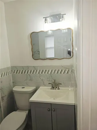 a bathroom with a toilet sink and mirror