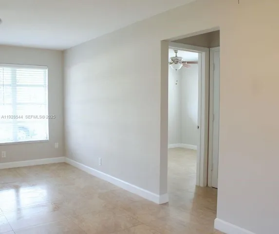 an empty room with a window and a bathroom