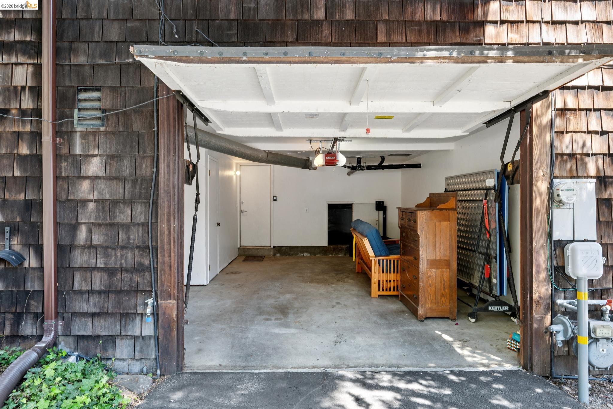 1340 Henry Street Berkeley, CA 94709 - Photo 48 of 52 Attached garage with concrete flooring, white painted walls, and an overhead garage door opener