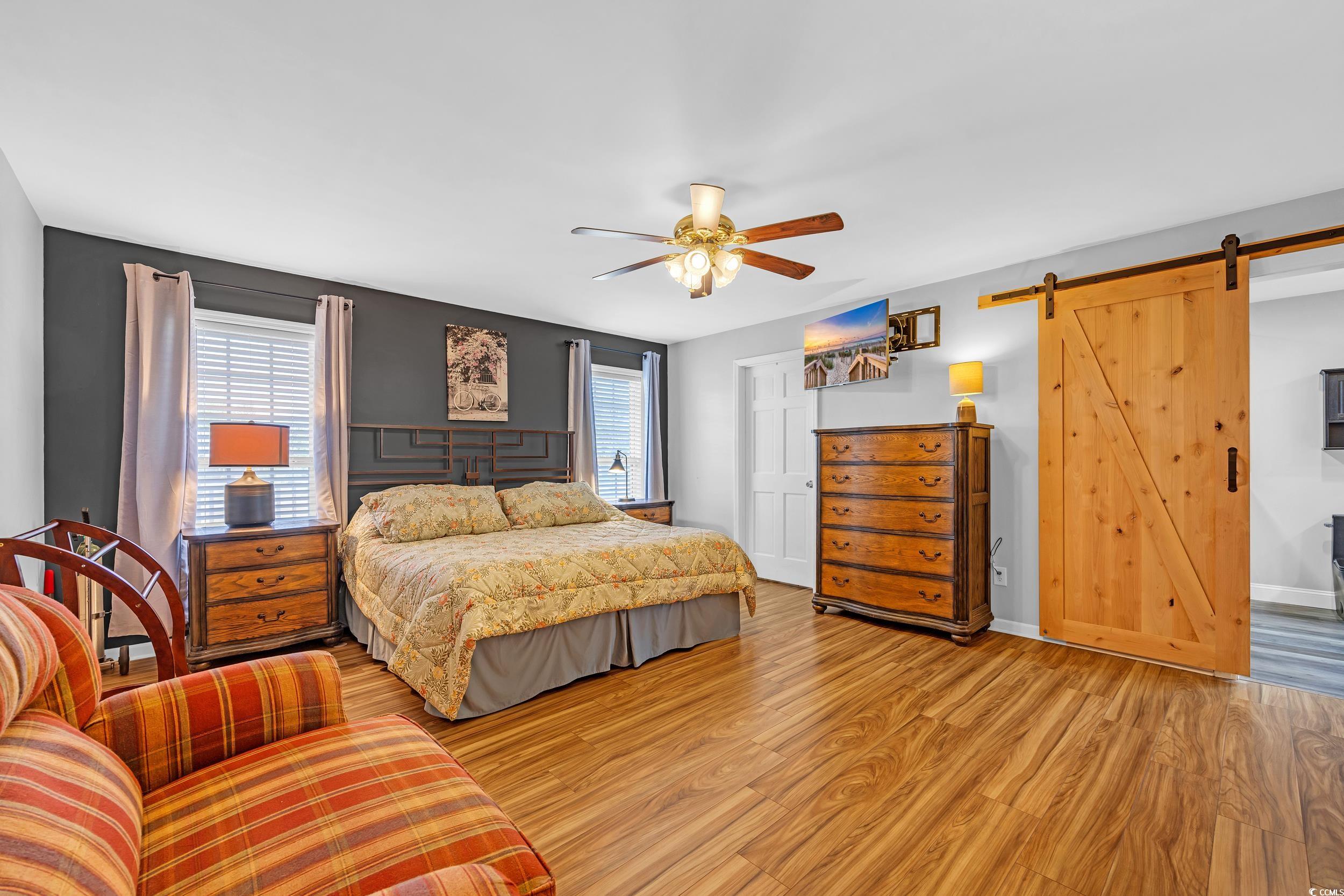 1014 Academy Drive Conway, SC 29526 - Photo 10 of 40 Bedroom with ceiling fan, a barn door, and light w