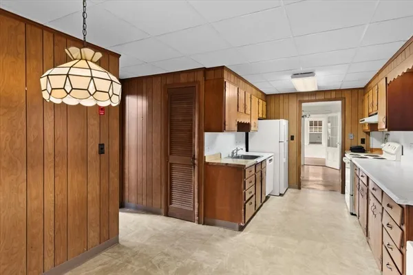 a kitchen that has a lot of cabinets stainless steel appliances and a window