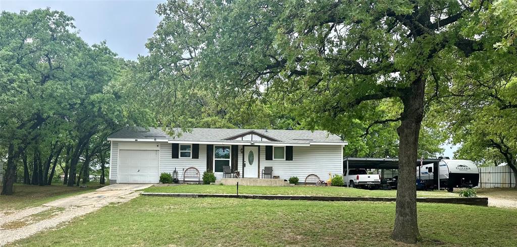 186 Garnet Road Springtown, TX 76082 - Photo 1 of 1 a front view of a house with a garden