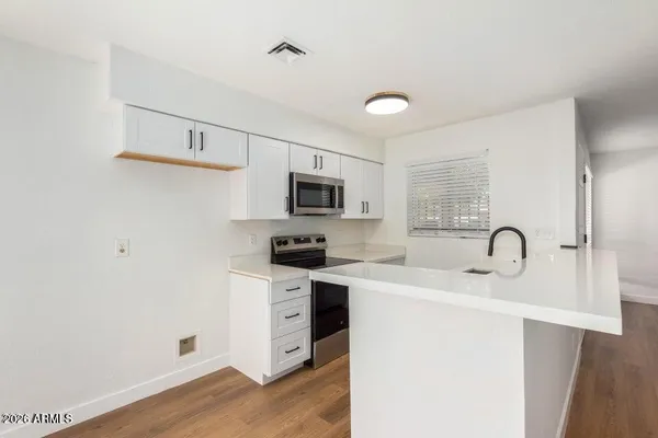 a kitchen with stainless steel appliances granite countertop a sink a stove top oven a counter space and cabinets