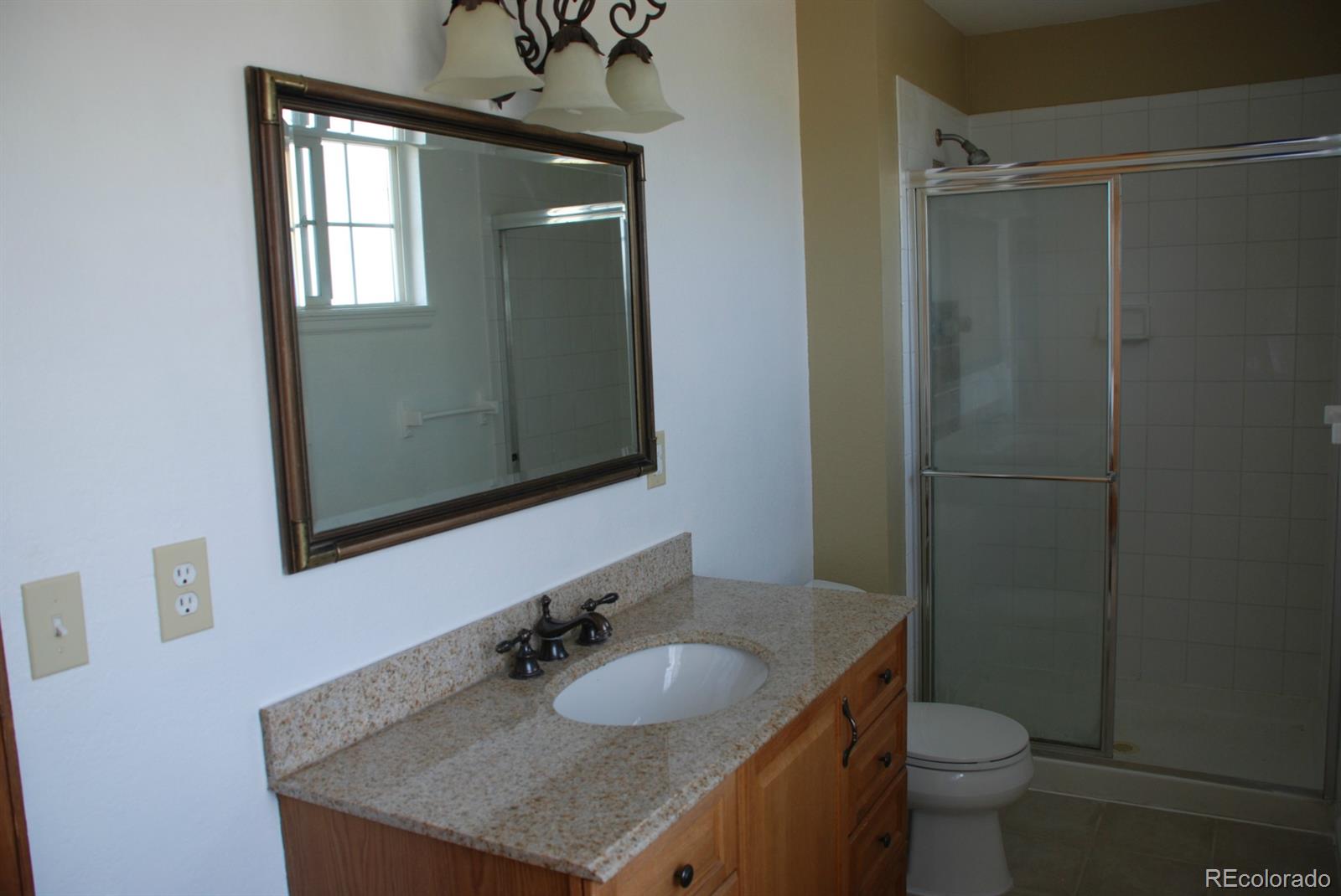 8979 Lariat Loop Elizabeth, CO 80107 - Photo 3 of 17 a bathroom with a granite countertop sink toilet and mirror
