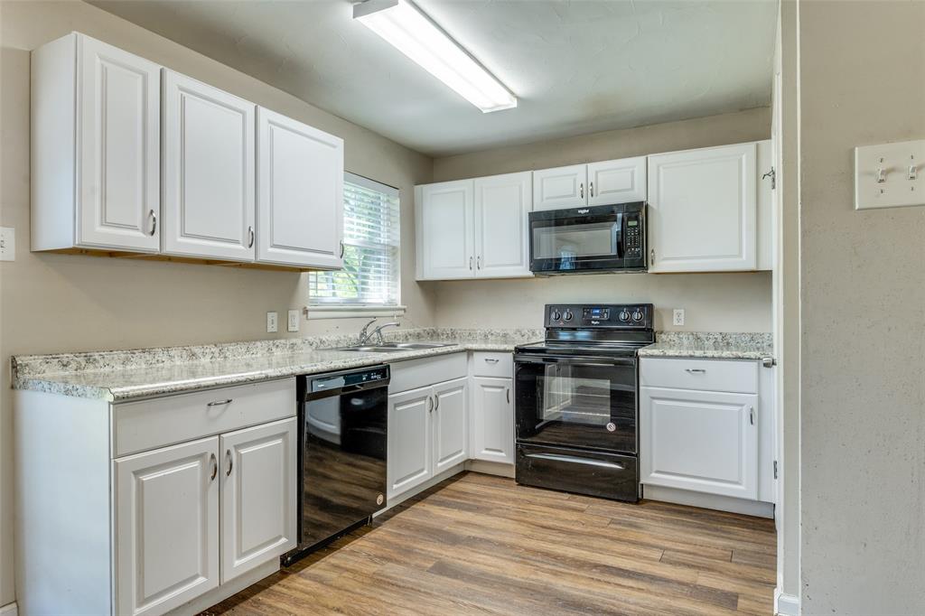 4312 Ridgedale Drive Mesquite, TX 75150 - Photo 6 of 23 a kitchen with granite countertop white cabinets and white appliances