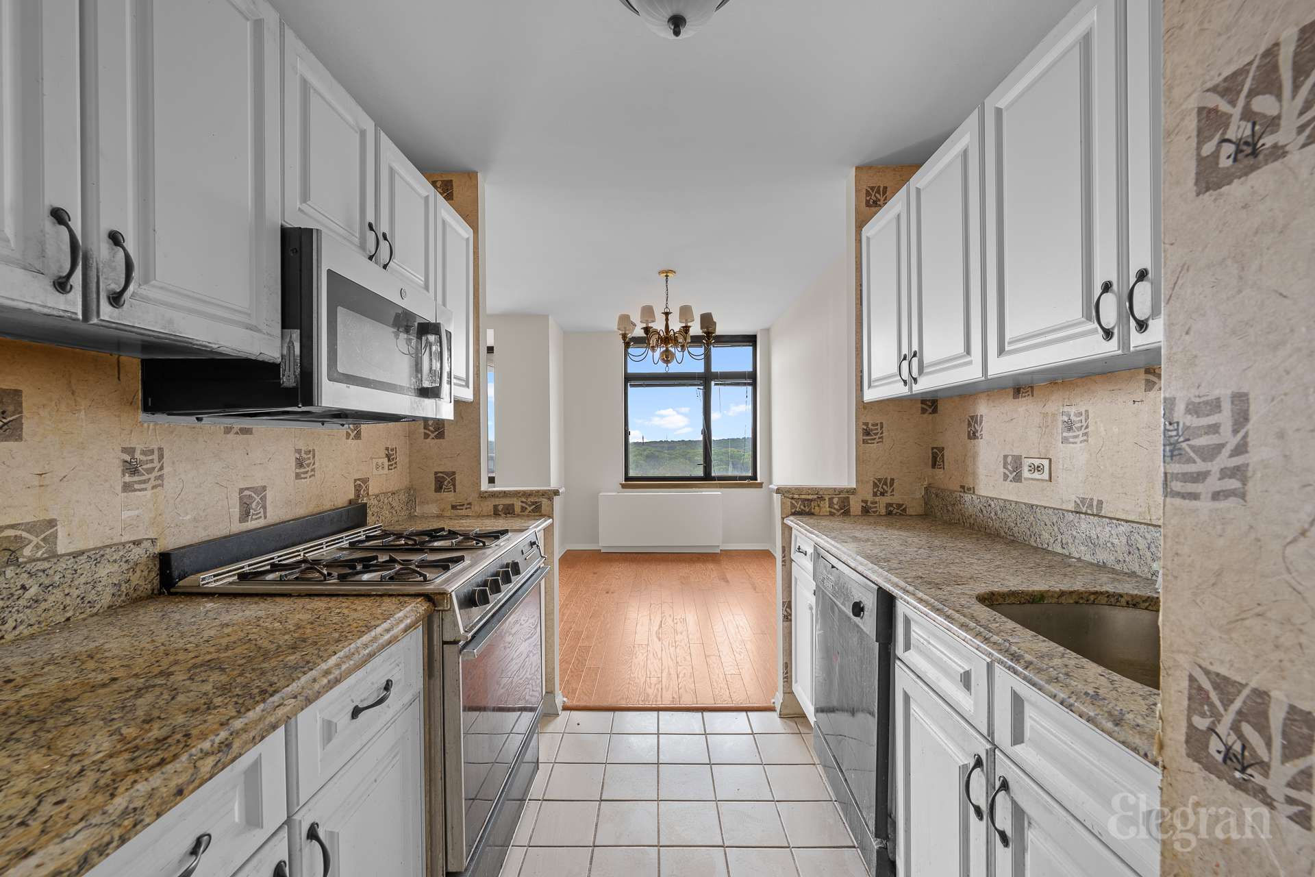 112-01 Queens Boulevard, Unit 16F Queens, NY 11375 - Photo 3 of 24 a kitchen with granite countertop a sink a stove and cabinets
