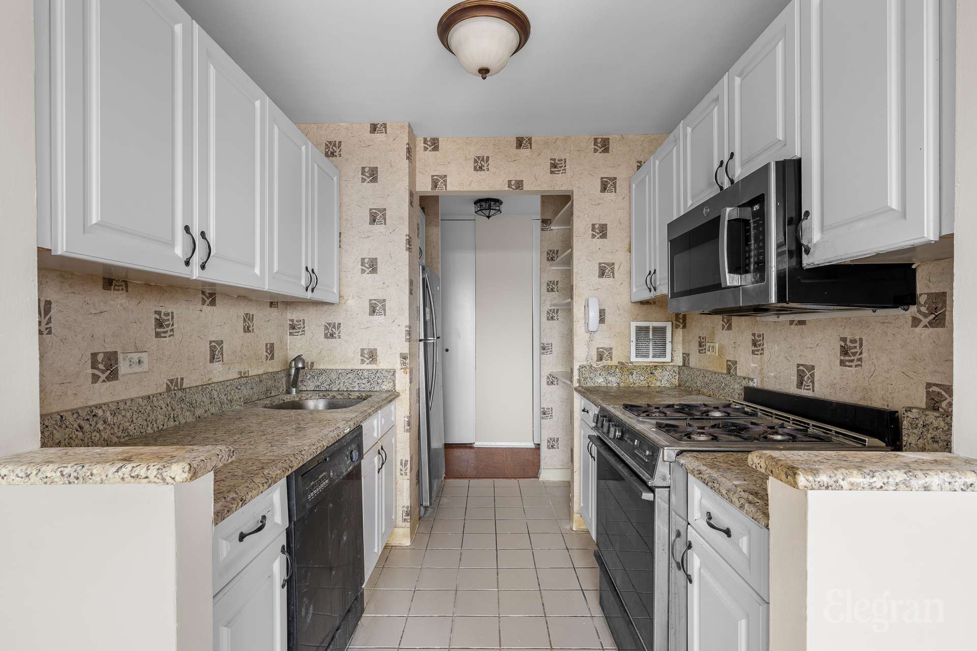 112-01 Queens Boulevard, Unit 16F Queens, NY 11375 - Photo 4 of 24 a kitchen with stainless steel appliances granite countertop a stove a sink and a microwave