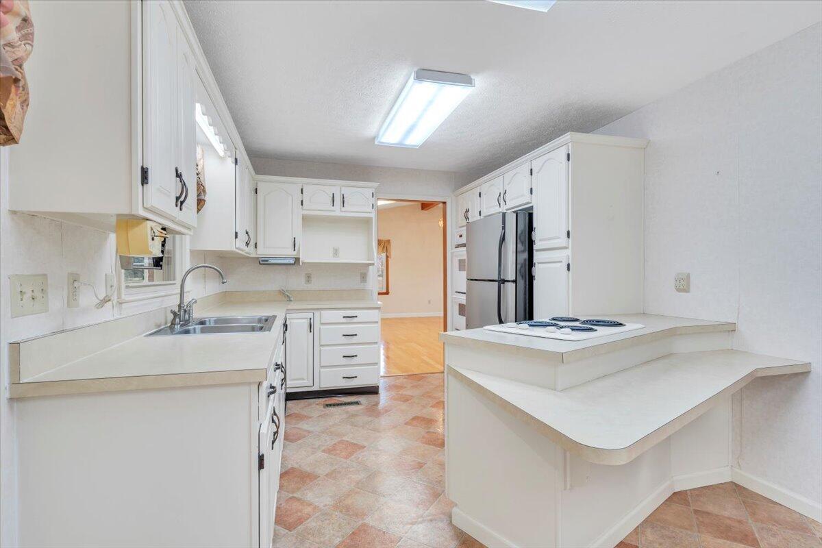 5985 Collier Street Dublin, VA 24084 - Photo 26 of 53 a kitchen with granite countertop a sink stove and refrigerator