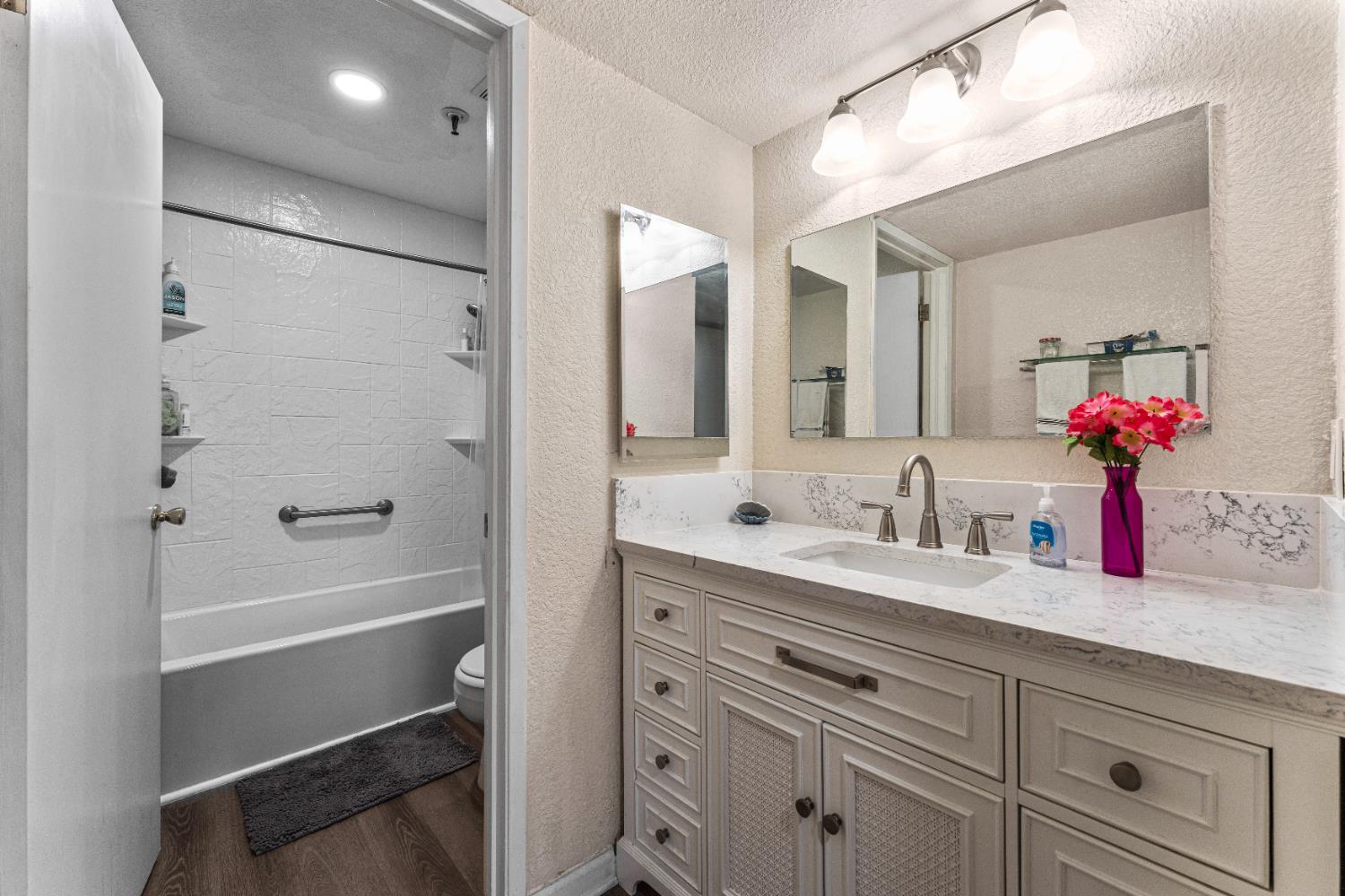 1019 Dornajo Way, Unit 123 Sacramento, CA 95825 - Photo 15 of 23 a bathroom with a granite countertop sink mirror and a shower