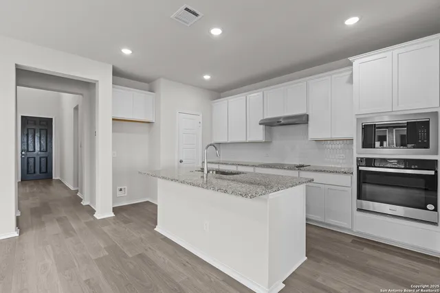a kitchen with stainless steel appliances granite countertop a stove and a refrigerator