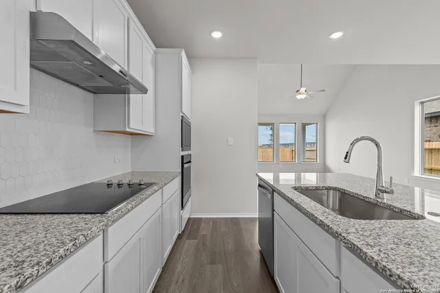 a kitchen with granite countertop a sink and cabinets