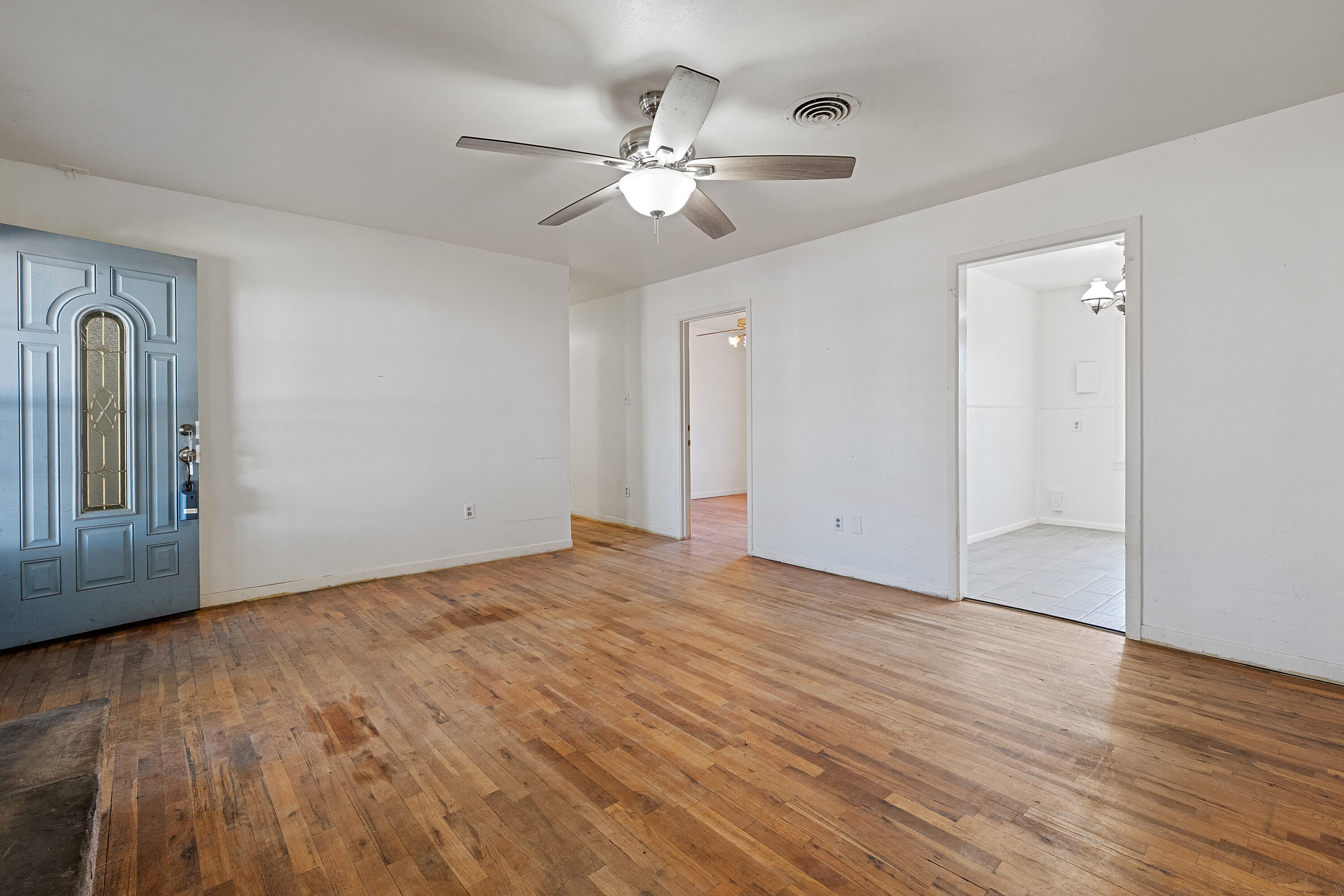 705 6th Street Wolfforth, TX 79382 - Photo 7 of 29 a view of an empty room with wooden floor and a ceiling fan