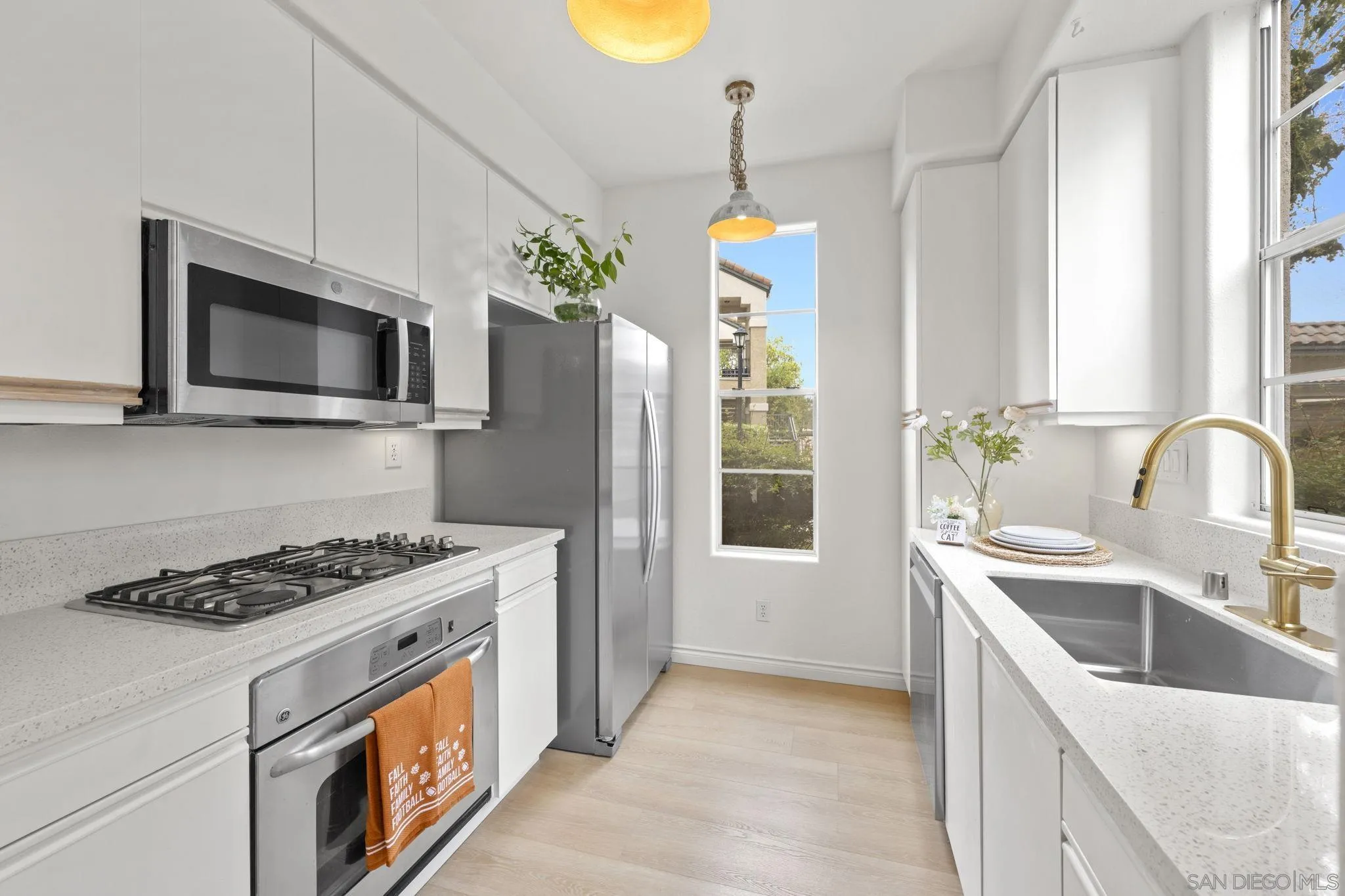 a kitchen that has a microwave a stove and a sink