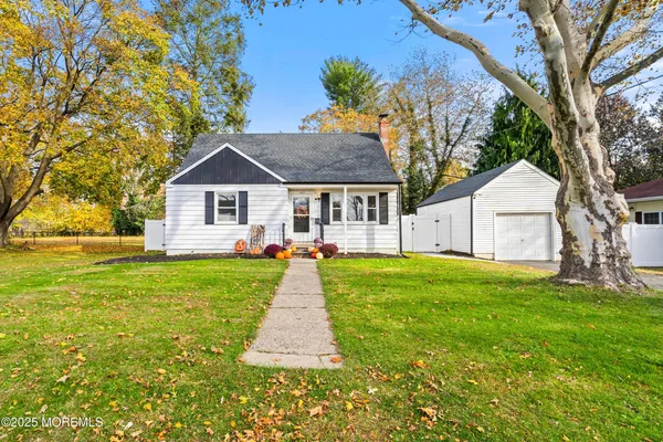 a front view of a house with a yard and trees