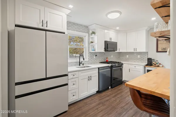 a kitchen with stainless steel appliances a refrigerator sink and microwave