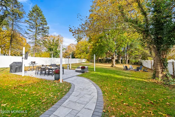 a view of a swimming pool with lawn chairs and a big yard