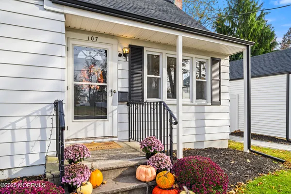 a view of a porch with a table and chairs and floor to ceiling window