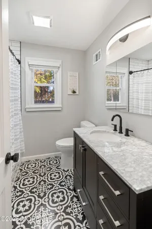 a bathroom with a granite countertop sink and a mirror