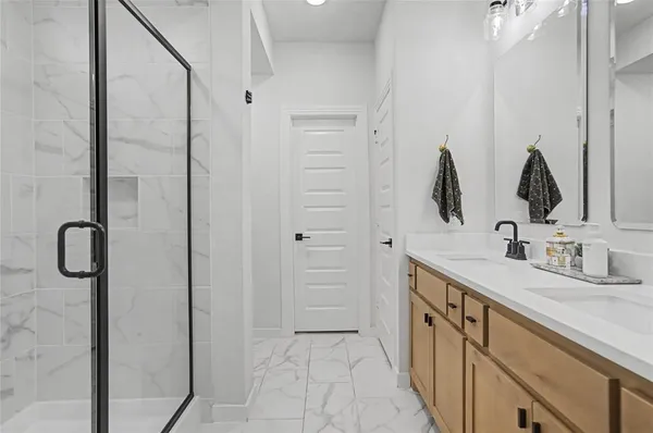 a bathroom with double vanity sinks and a mirror