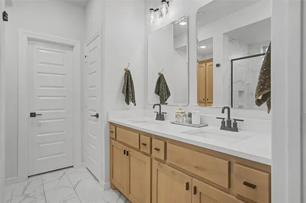 a bathroom with double vanity sink and two mirror