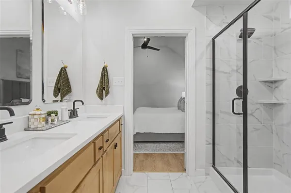 a bathroom with a granite countertop sink mirror and shower