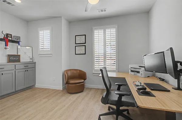 a view of a workspace with furniture and a window