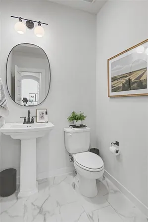a bathroom with a toilet a sink and mirror