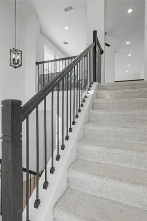 a view of staircase with lots of frames on wall and a window