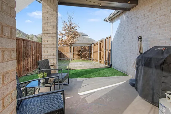 a backyard of a house with a garden and outdoor seating