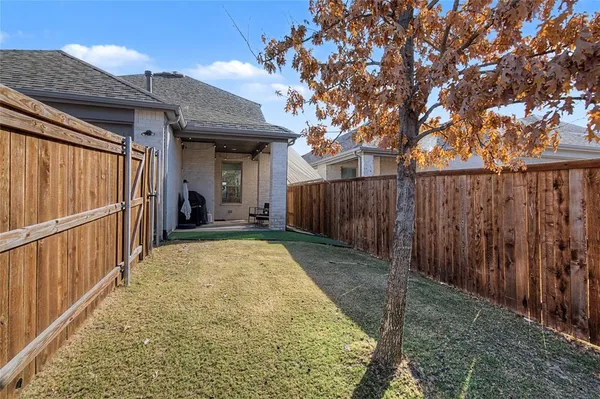 a view of backyard with small cabin and wooden fence