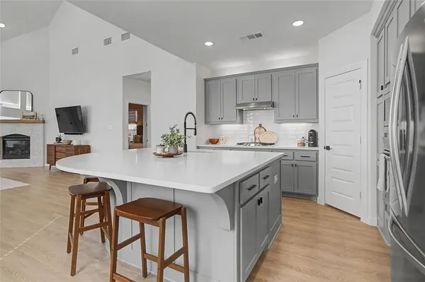 a kitchen with a sink a refrigerator and chairs