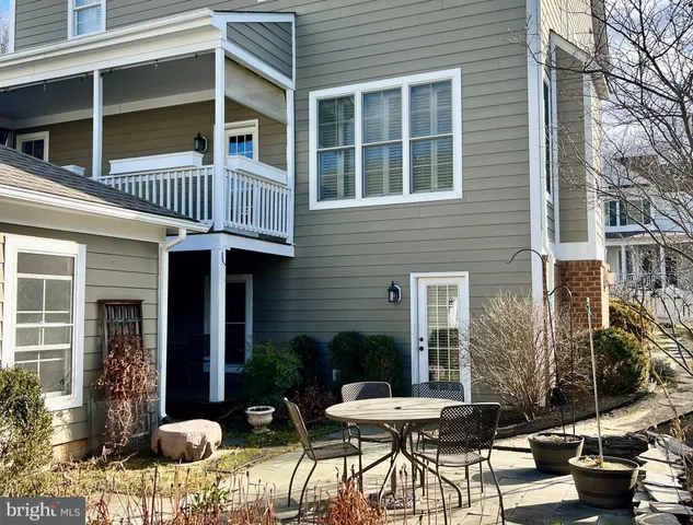 a view of a brick house with a chairs and table in a patio