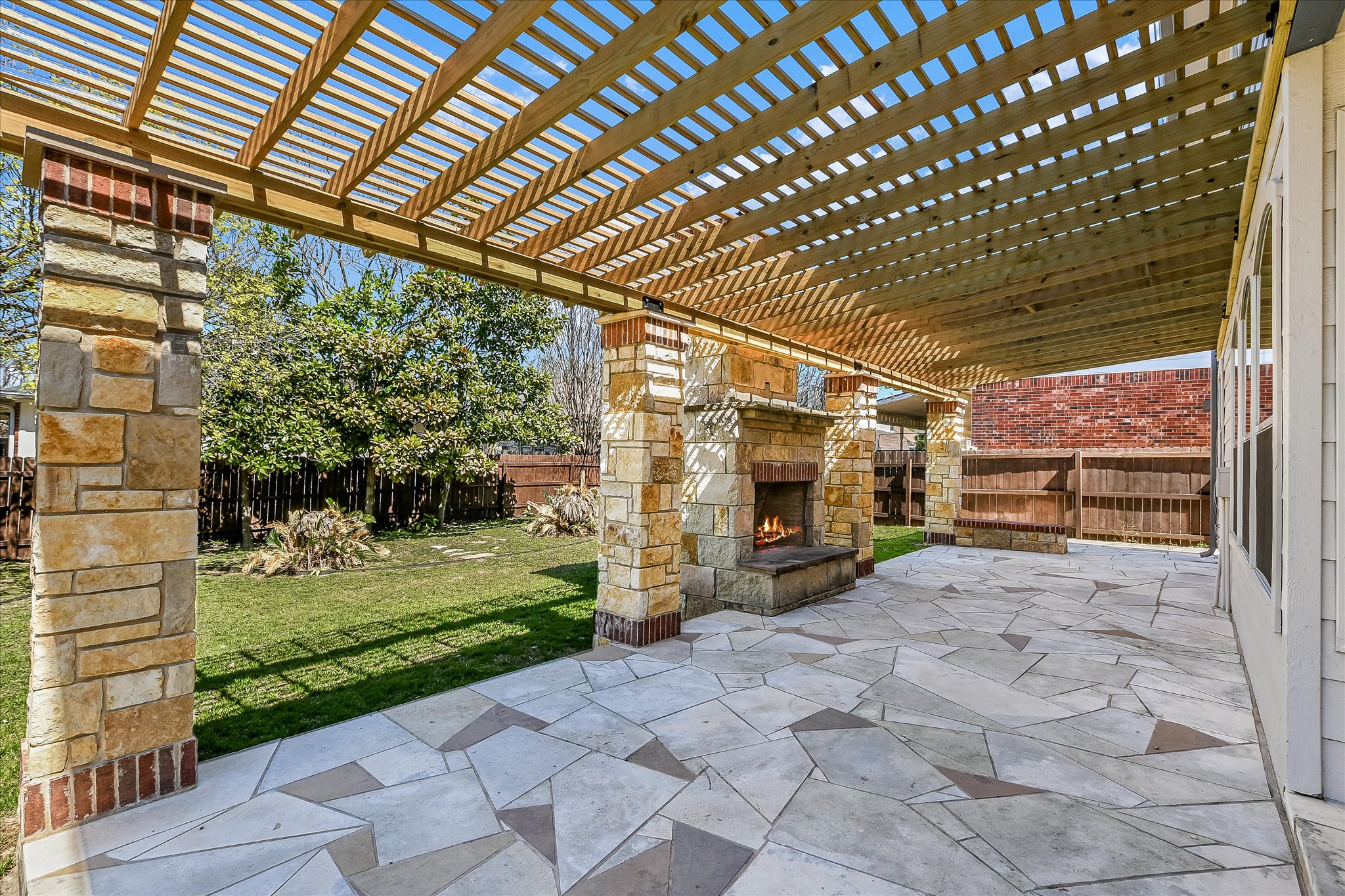 3112 Raging River Drive Austin, TX 78728 - Photo 1 of 1 View of patio / terrace with an outdoor stone fireplace and a fenced backyard