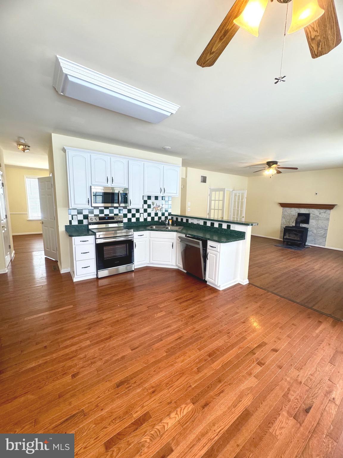 14410 Stottlemyer Road Smithsburg, MD 21783 - Photo 10 of 24 a large kitchen with stainless steel appliances granite countertop a stove and a wooden floors