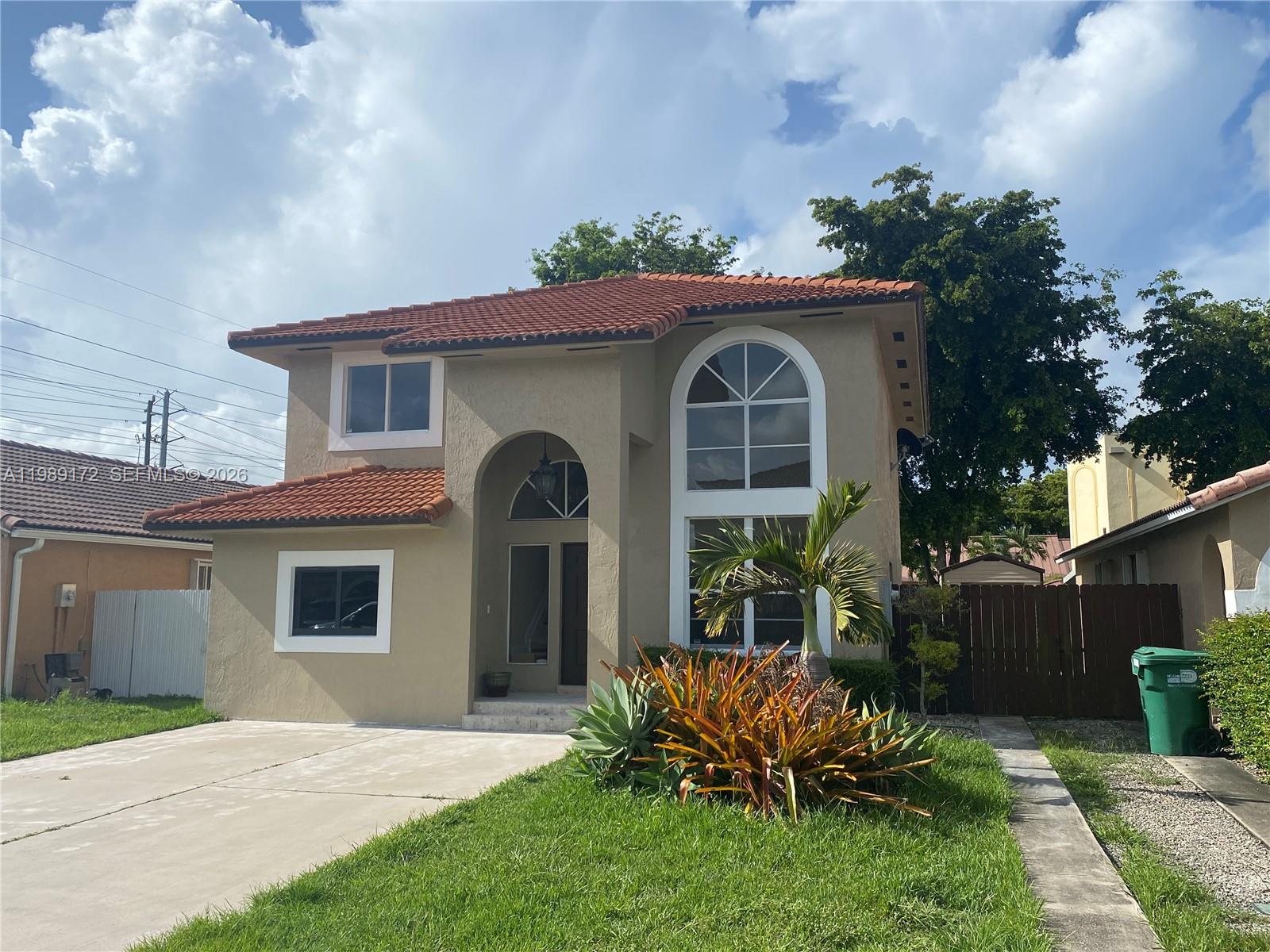7632 Northwest 166th Terrace Hialeah, FL 33015 - Photo 1 of 20 a front view of a house with a garden and yard